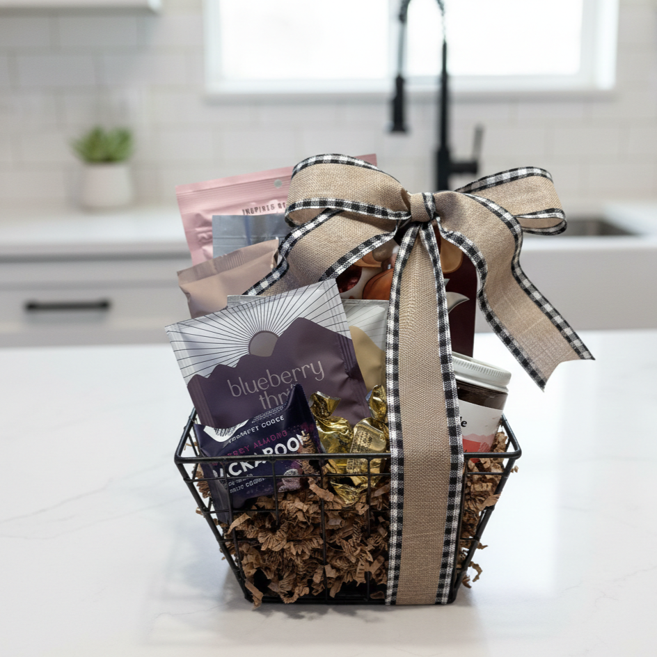 Fairbanks Alaska Gift Basket with blueberry thins, gold-foil chocolates, a jar of Barnacle jam, and more, elegantly tied with a burlap gingham ribbon.