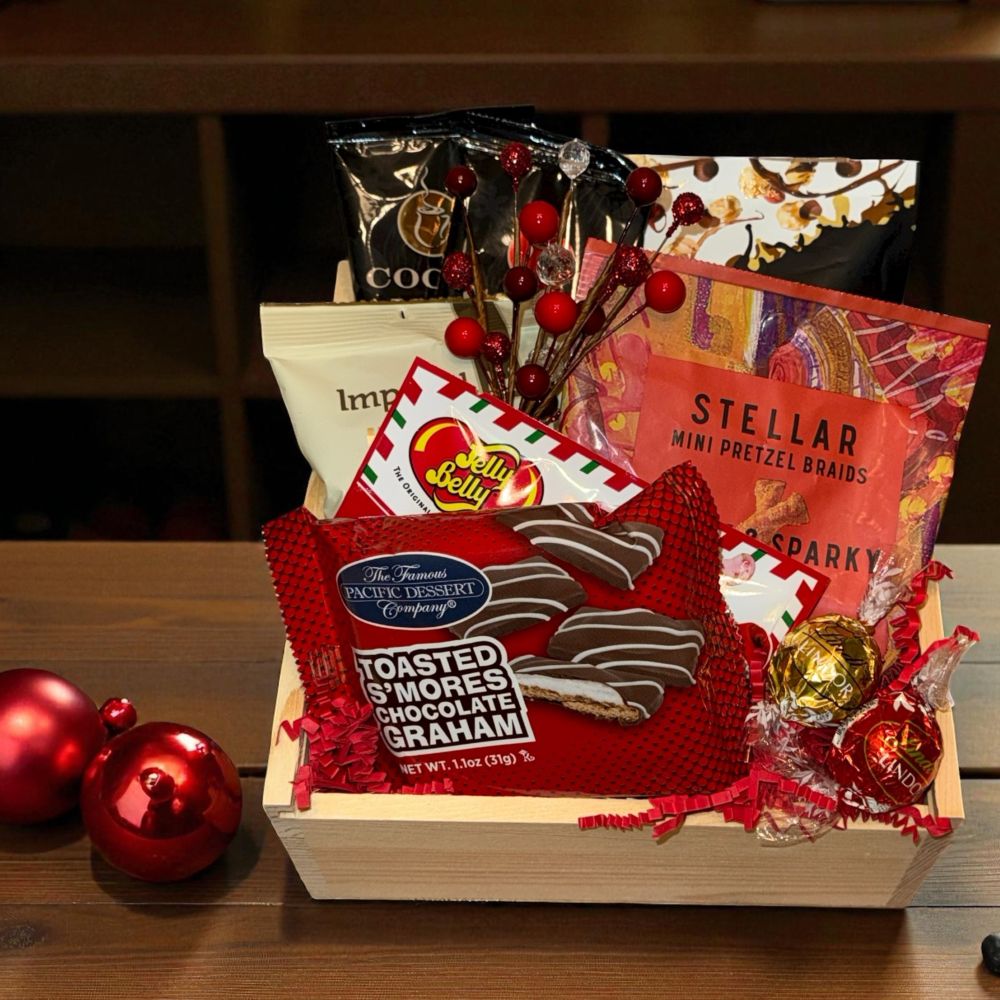 Gift basket with snacks and treats on a wooden surface