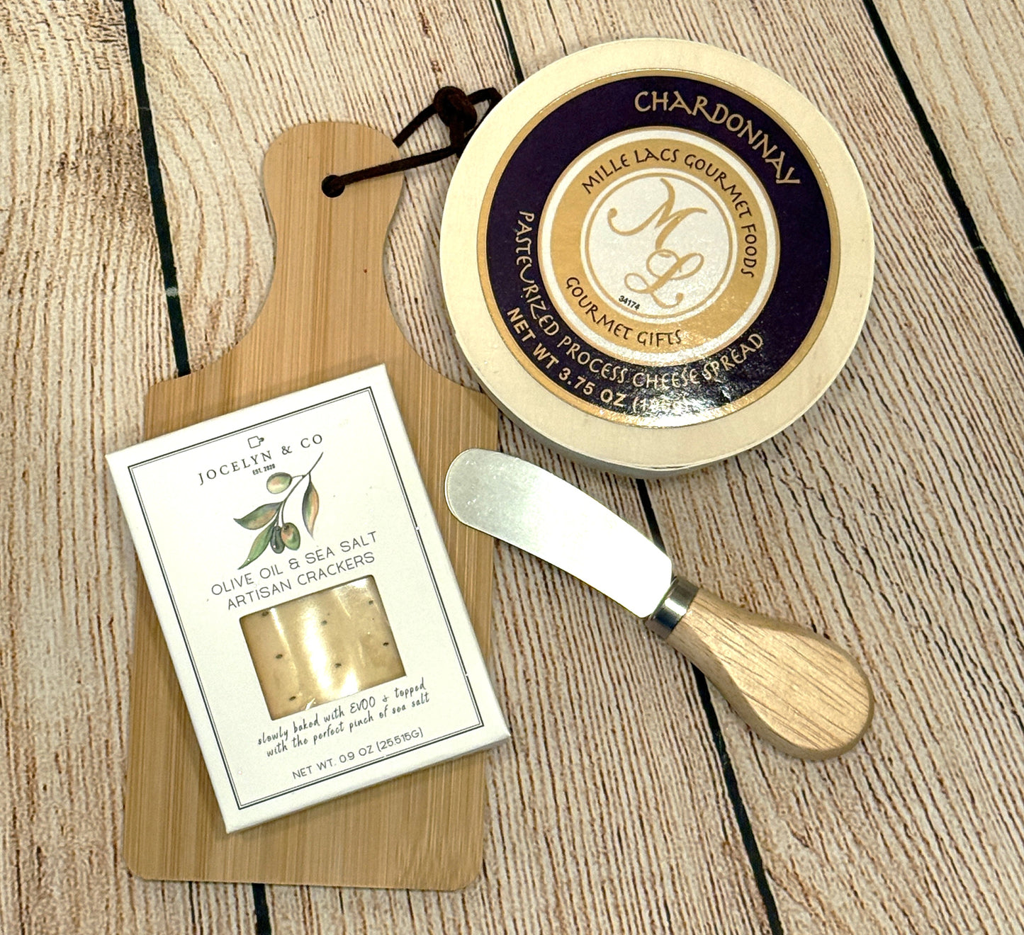 Cheese spread with a knife and crackers packaging on a wooden surface