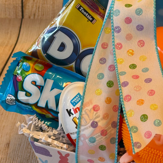 Peep Peep Easter Basket - Blue with Dots gumdrops, Skittles, Kinder egg, polka-dot ribbon, Easter bunny container, and an orange stress-ball toy.
