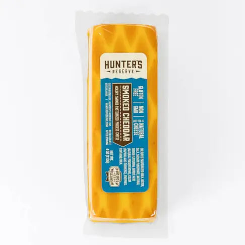 Block of smoked cheddar cheese with 'Hunter's Reserve' label on a white background