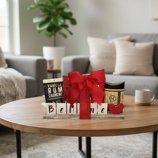 Gift basket with a red ribbon on a coffee table in a living room.