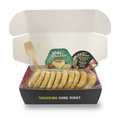 Open box containing a package of cookies with cheese-themed packaging on a white background