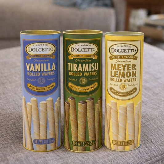 Three tubes of Dolcetto gourmet cookies with different flavors on a surface.