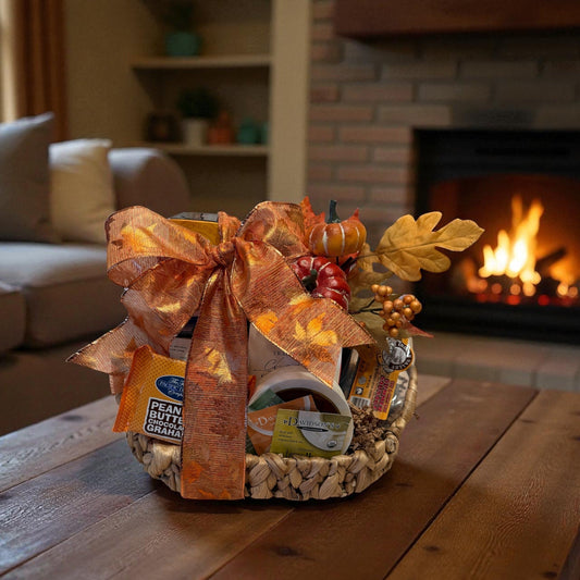 Gift basket with a fall-themed arrangement on a wooden table in a cozy living room.