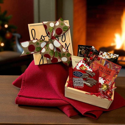 Decorative gift set with a book and small items on a red cloth in front of a fireplace.