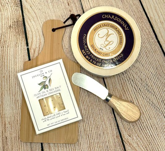 Cheese spread with a knife and crackers packaging on a wooden surface