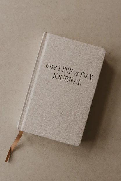 Beige journal with 'one LINE a DAY JOURNAL' text on a beige background