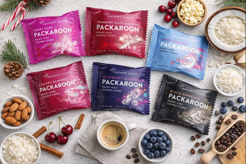 Heather's Choice Packaroons: six gluten-free, dairy-free, plant-based coconut cookies in assorted flavors, arranged with matching ingredients like coconut flakes, almonds, and coffee beans.
