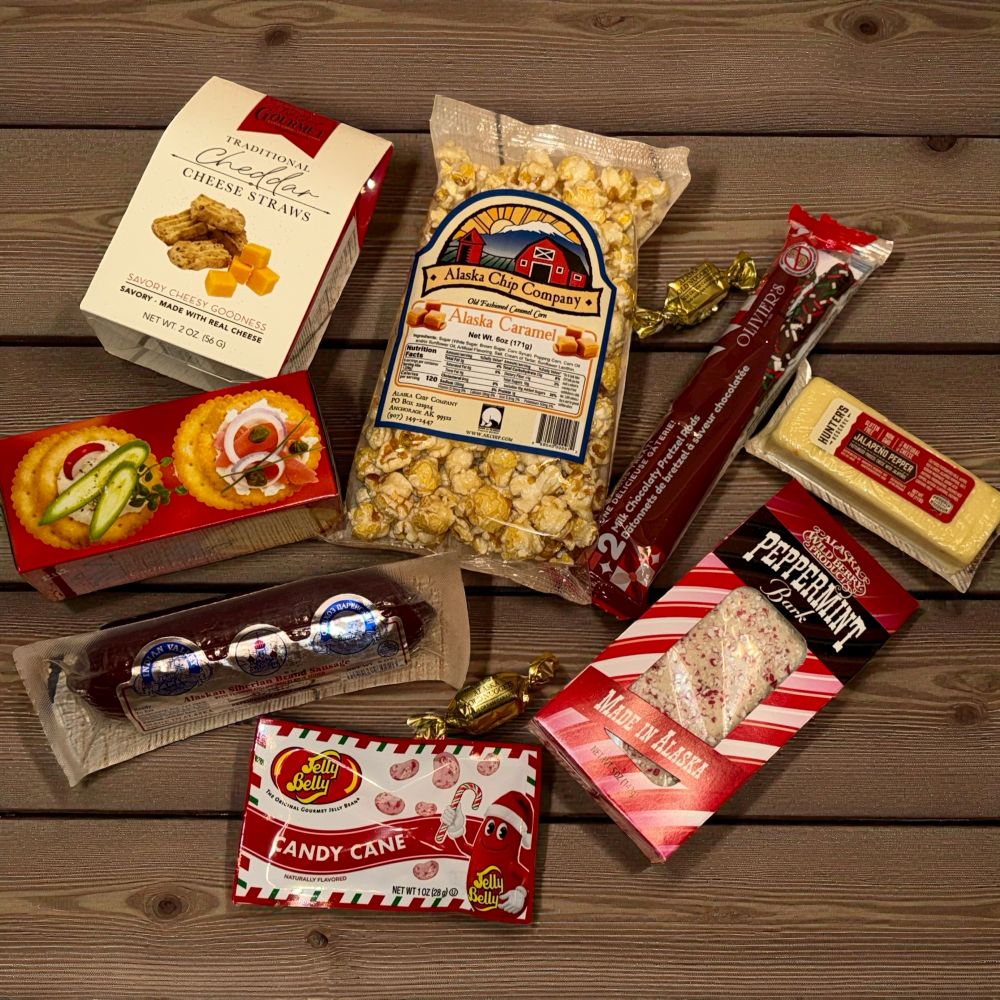 Assorted snack items including popcorn, candy, and cookies on a wooden surface