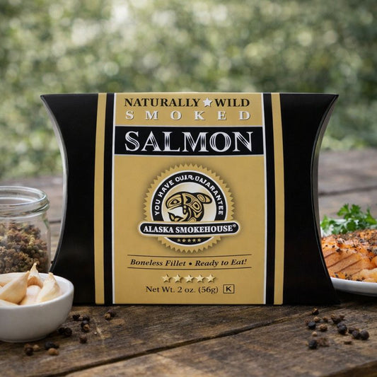 Packaged smoked salmon with Alaska Smokehouse branding on a wooden surface.