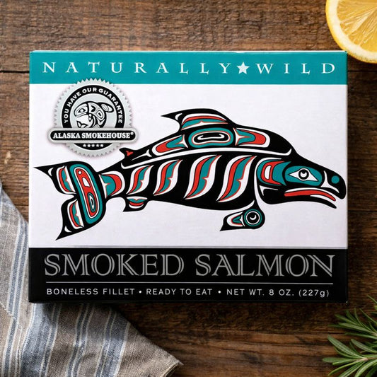 Naturally Wild Alaska Smokehouse smoked salmon packaging on a wooden surface with a lemon wedge.