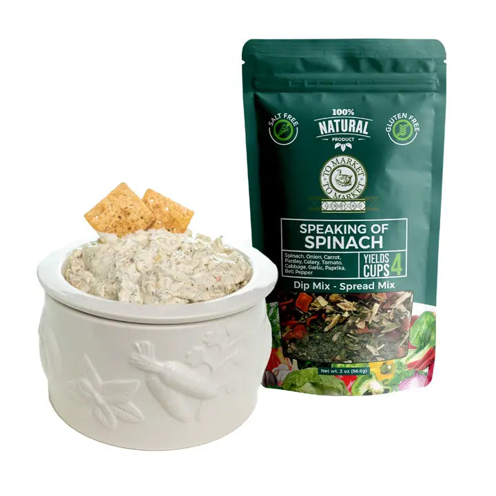 Dip mix in a white bowl with crackers and a package of 'Speaking of Spinach' dip mix on a white background