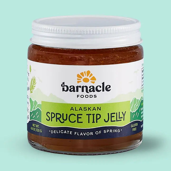 Jar of Alaskan Spruce Tip Jelly with Barnacle Foods label on a light green background