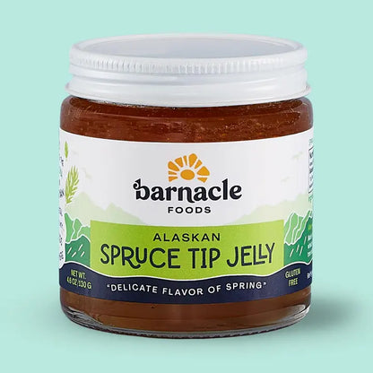 Jar of Alaskan Spruce Tip Jelly with Barnacle Foods label on a light green background