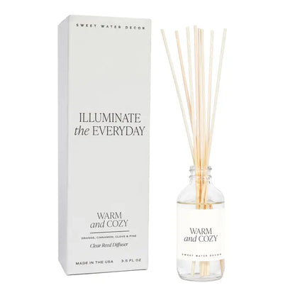 Diffuser with reeds and packaging labeled 'Sweet Water Decor' on a white background. Warm and Cozy Scent.