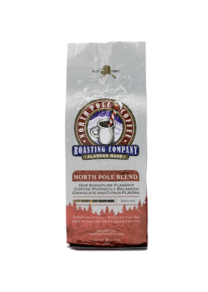 A package of North Pole Blend coffee by The Roasting Company with a white and red design, featuring an image of a polar bear and a pine tree.