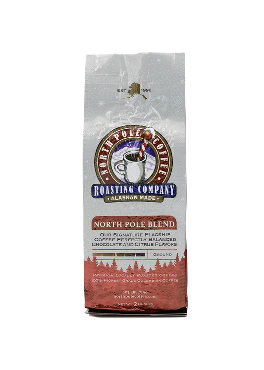 A package of North Pole Blend coffee by The Roasting Company with a white and red design, featuring an image of a polar bear and a pine tree.